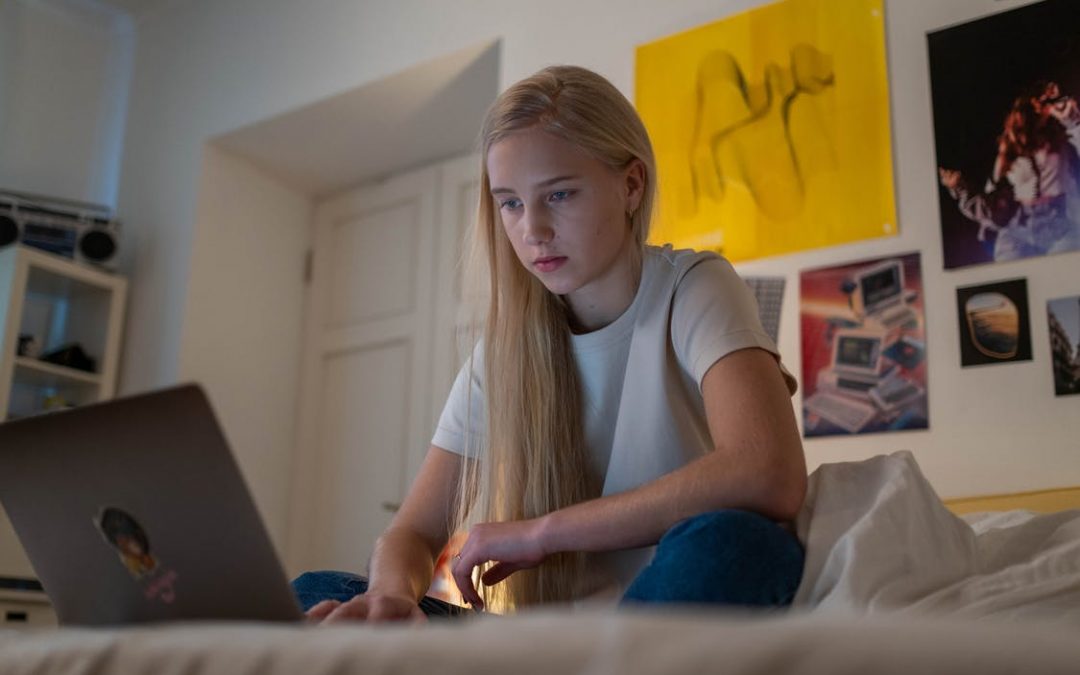 pige sidder på sin computer på hendes værelse